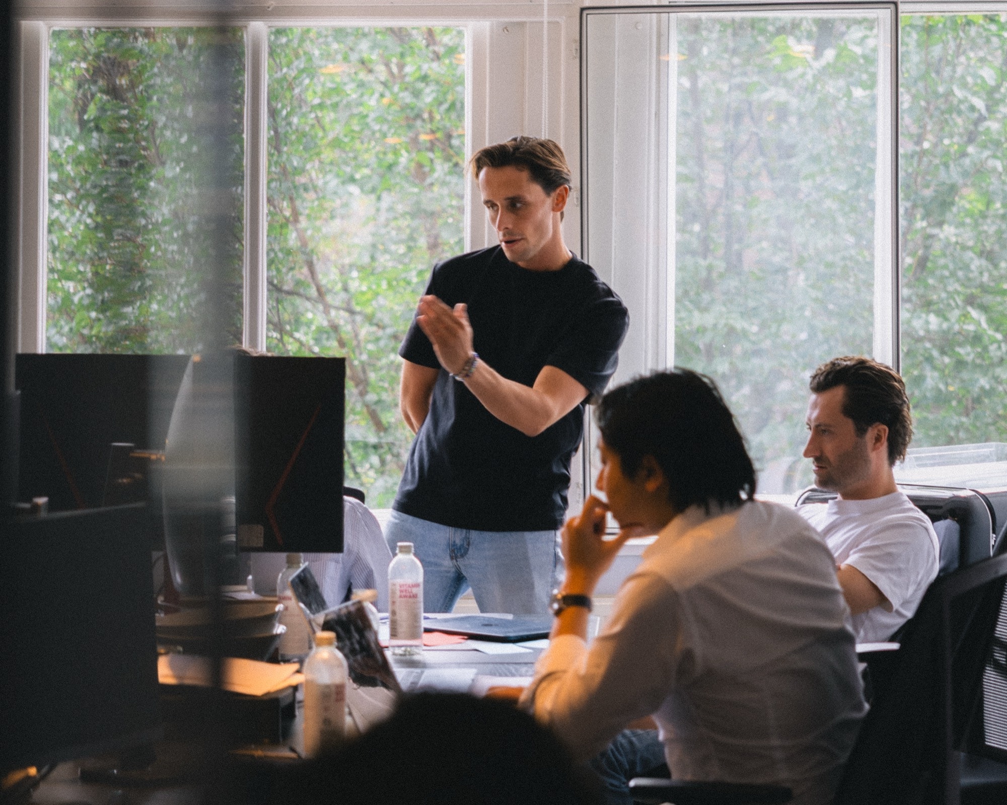 A standing discussion at the desks in the SKUU office