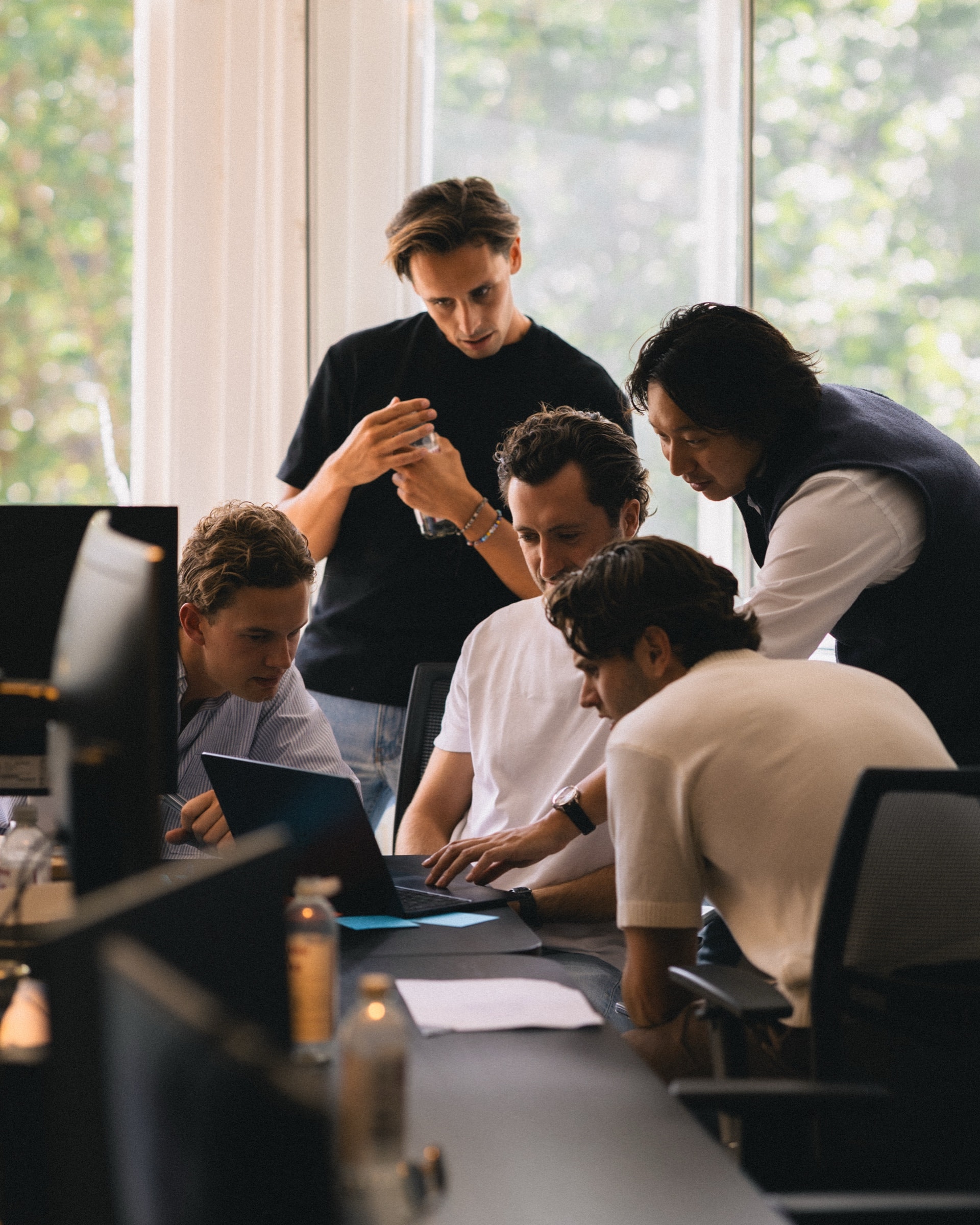 The team gathered around one laptop in the SKUU office